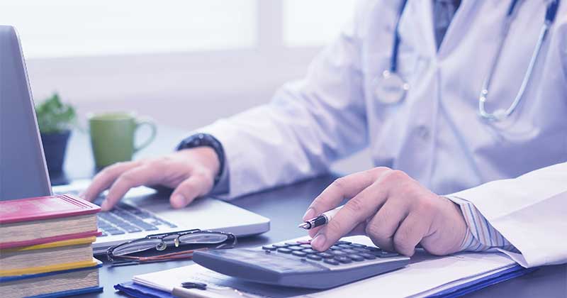 Doctor calculating with medical billing software