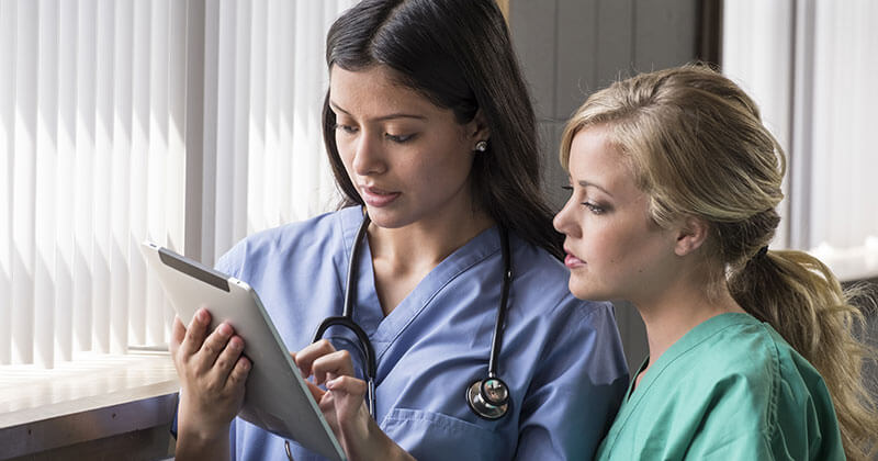 Physicians looking at a mobile EHR on iPad