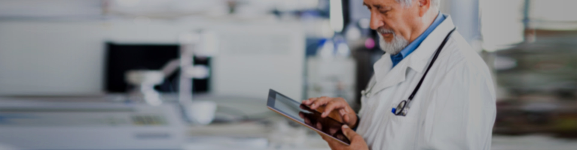 A doctor smiling while looking at an iPad