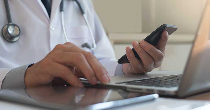 Doctor using web based medical billing software on iPhone