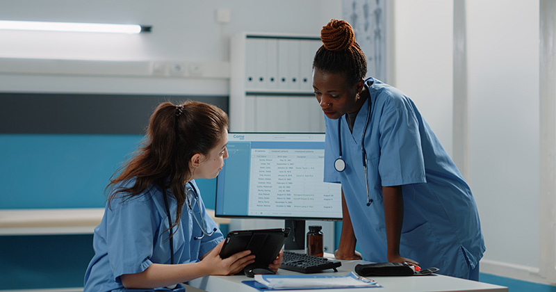 Medical professionals working together and consulting tablet