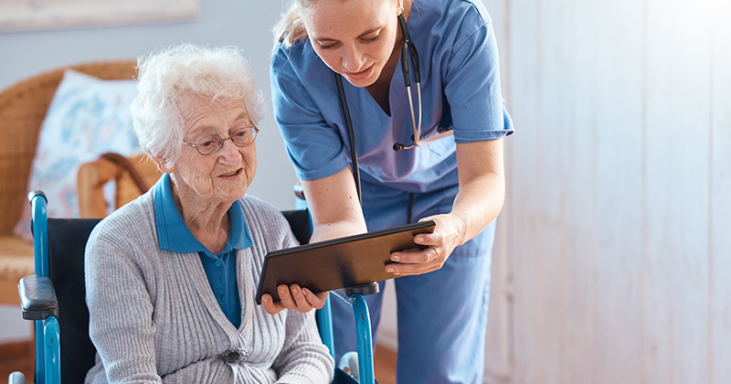 NURSE WITH ELDERLY MAN AND IPAD