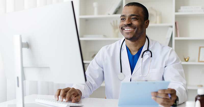 Doctor smiling with desktop