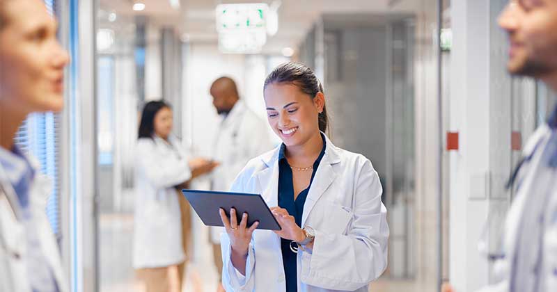 Doctor watching tablet at the hall