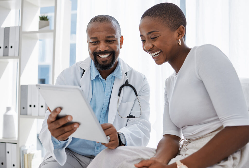Doctor, healthcare and medicine with a patient talking test results and progress on a tablet in a hospital clinic. Trust, help and medical consulting with a professional medicare worker in his office.