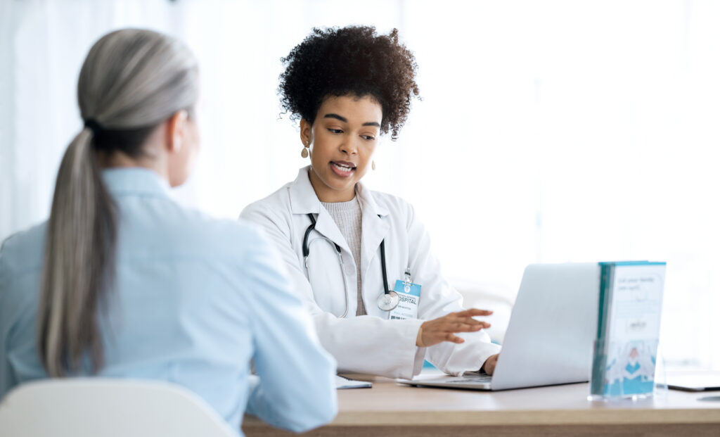 Doctor, woman and computer for healthcare support, hospital services and patient history, charts or results in office. Medical professional and client on laptop for consultation information or advice.