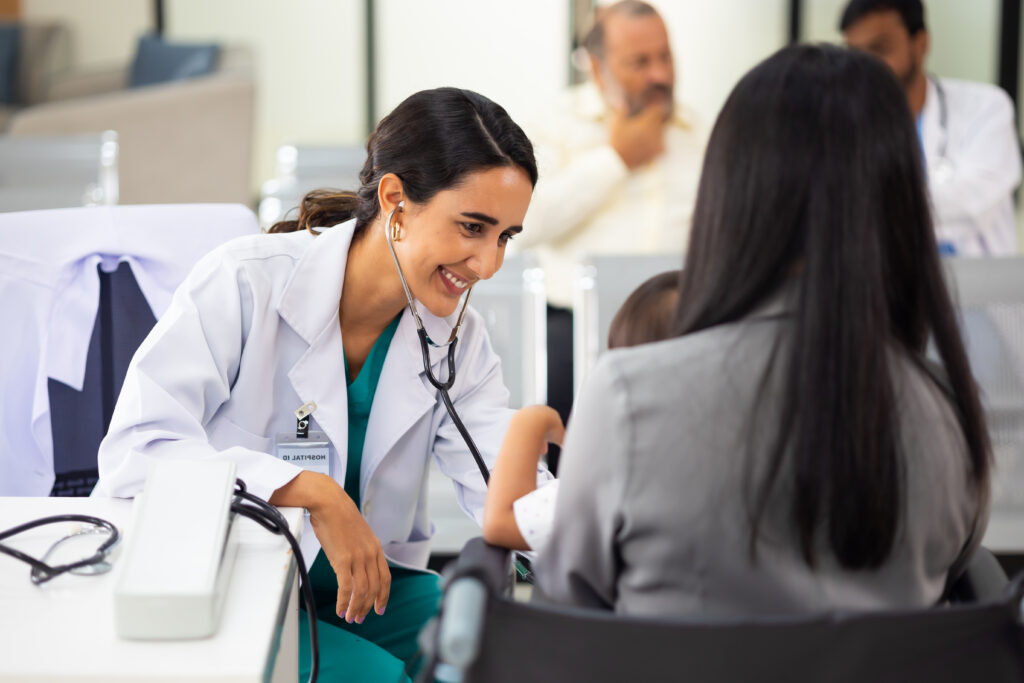 pediatrician : Hispanic Brazilian woman Doctor working with little asian boy patient and family at hospital and wellness center.