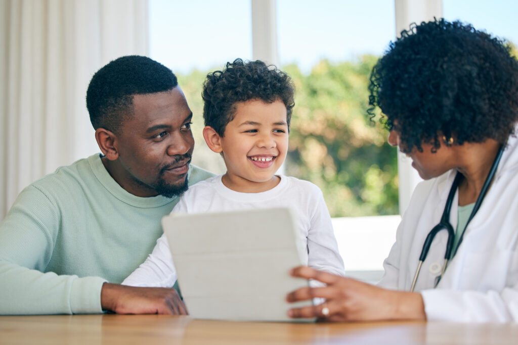Pediatrician tablet, dad and child with a smile from patient results with good news at a hospital. Happy kid, father and doctor in a clinic consultation office with a healthcare worker and family.
