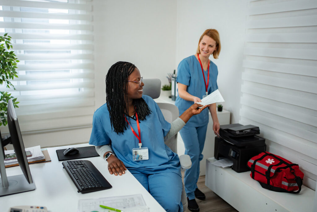 Two doctors or nurses exchanging documents, working together in a modern healthcare setting