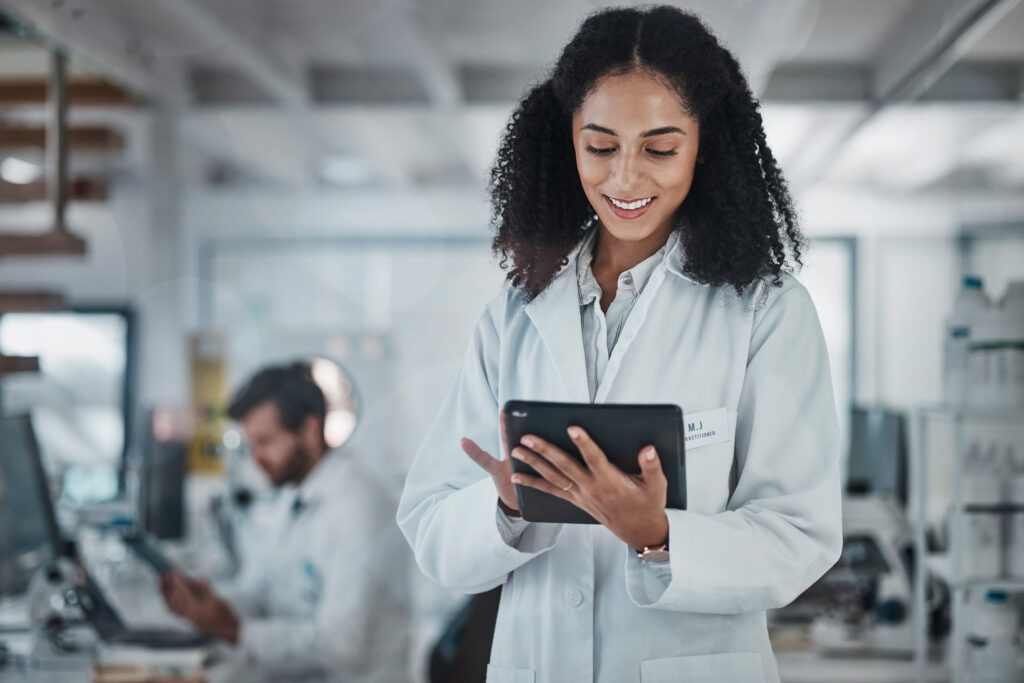 Science, research and black woman with tablet, smile and internet in laboratory with medical data. Healthcare, pharmaceutical innovation and scientist, technology and reading email, website or result.