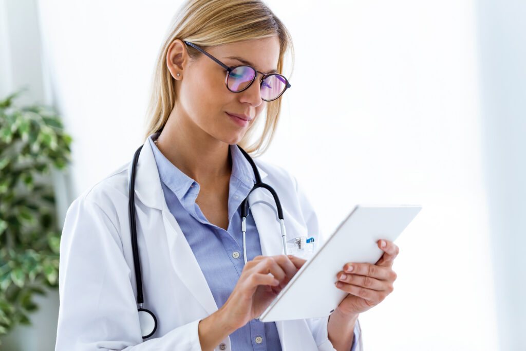 How AI Scribe Software Supports Smarter CPT and HCPCS Coding Shot of female doctor using her digital tablet in the consultation.