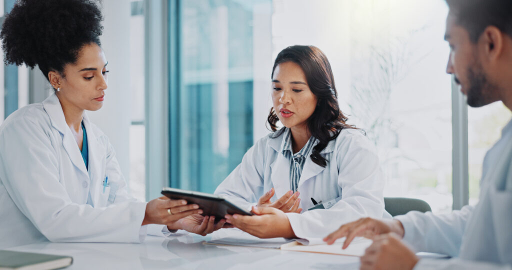 How AI Scribe Software Supports Smarter CPT and HCPCS Coding Doctor, meeting and tablet with planning, conversation and collaboration for surgery in a hospital. Technology, healthcare and medical professional group with teamwork and communication for clinic.