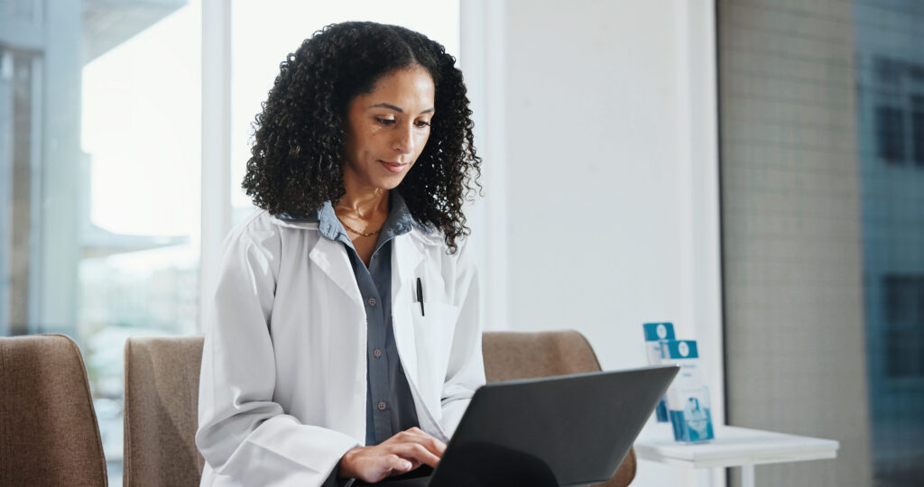 Benefits of Integrated Electronic Prior Authorization Tools Healthcare, doctor and woman with laptop in hospital for admin, insurance info or typing report. Computer, clinic worker and female person with schedule, research and email with medical records.