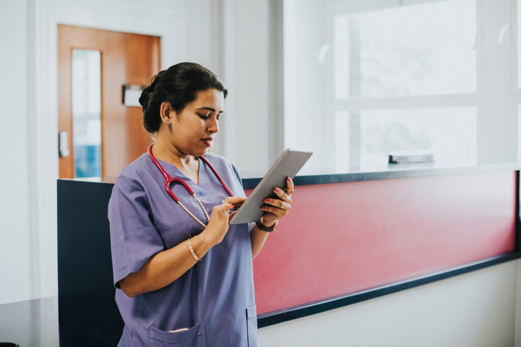 The Challenges Practices Face When Switching EHR Software Female nurse checking the schedule on a tablet