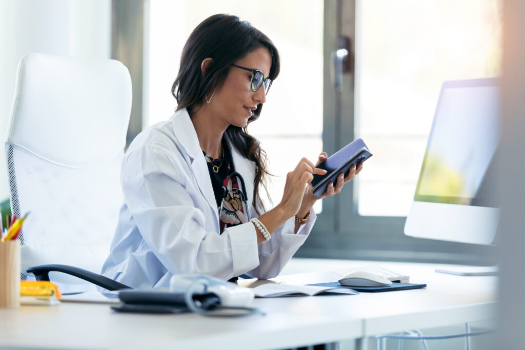 What Patients Expect From Modern Healthcare Apps Shot of pretty young woman gynecologist using her mobile phone before starting consultation in the clinic.