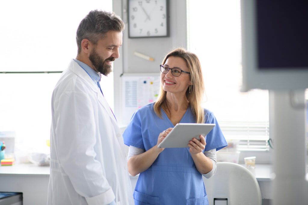 How Practices Can Improve Medical Staff Efficiency Doctor and female nurse looking at test results in tablet. Healthcare workers in Doctor's Office, clinic.