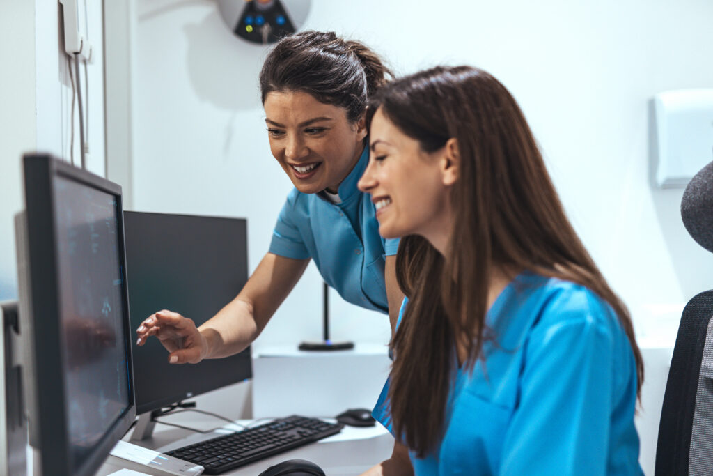 How Fax Automation Reduces Front-Office Administrative Work Two Medical Professionals Collaborating On Computer Tasks in an Office Setting