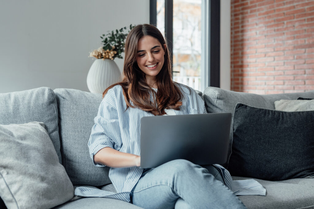 Streamlining the Transition to New Patient Portal Software Concentrated millennial girl sit on couch working on laptop browsing internet at home during lazy weekend, focused young woman freelancer busy using computer surfing wireless web shopping online