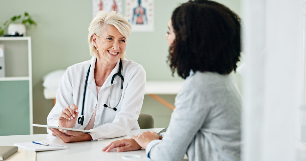 Happy woman, tablet and consulting with patient for medical results, diagnosis or prescription at hospital. Mature person or cardiologist talking to client in consultation with technology at clinic.