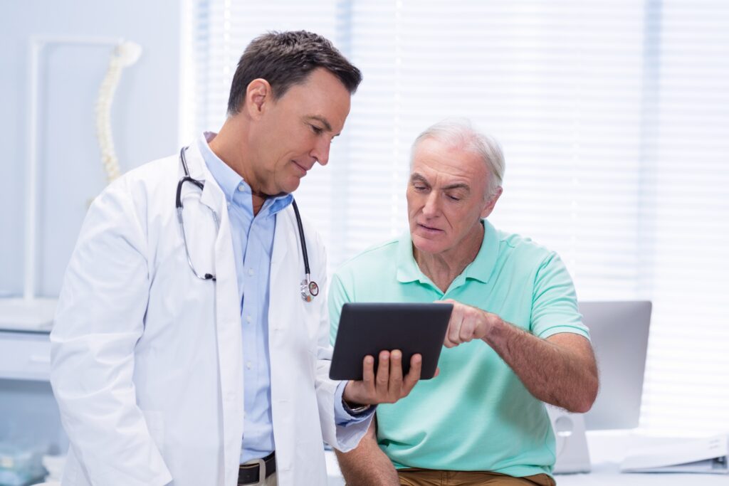 Why Front-End Patient Communication Impacts Operational Efficiency Doctor and senior patient using digital tablet