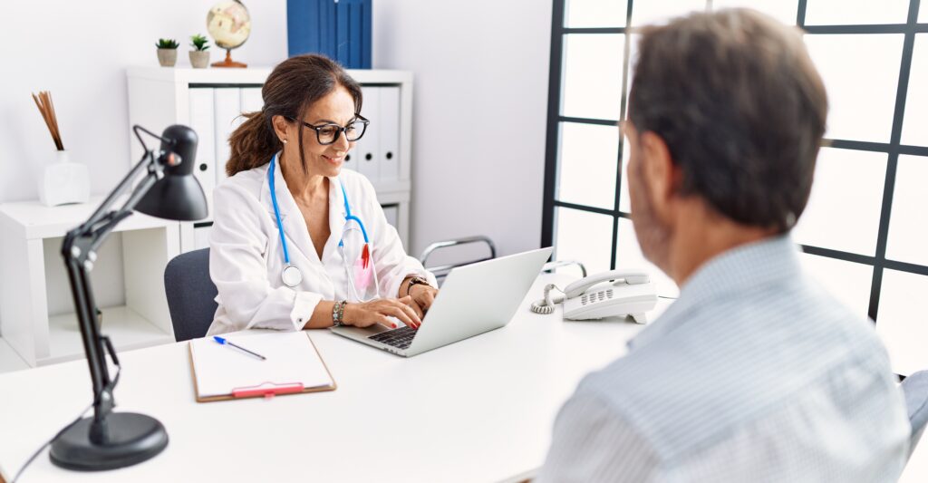 Middle age man and woman wearing doctor uniform having medical consultation at clinic