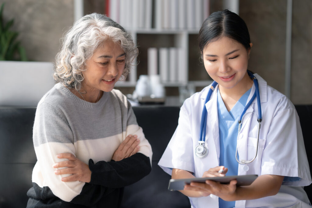 Creating a Connected Patient Scheduling Experience Across Web, Mobile, and Search Asian female doctor examining a patient to assess the illness for proper treatment.