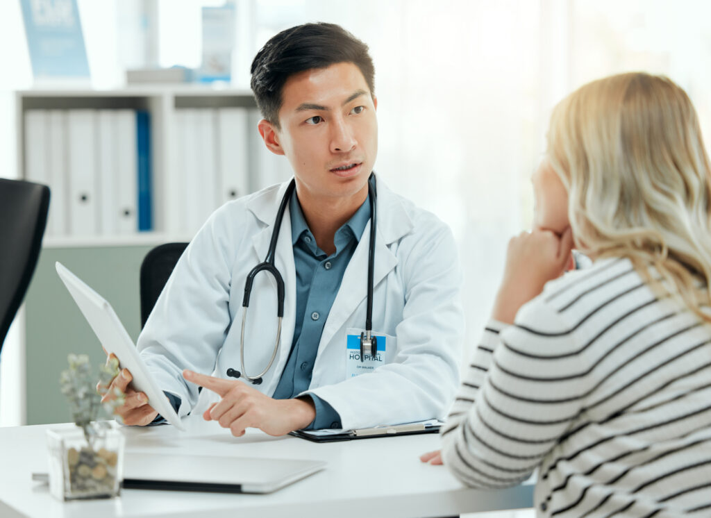 How AI Patient Summaries Improve Clinical Documentation Shot of a doctor during a consultation with a pregnant patient in a clinic.