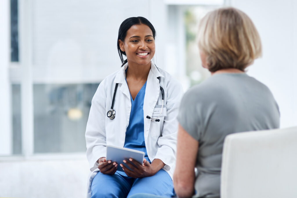 How AI Clinical Documentation Supports Financial Workflows Women, patient and doctor with a tablet, consultation and conversation for diagnosis, cure and treatment. Medical professional, employee and female person in a hospital, technology and discussion.